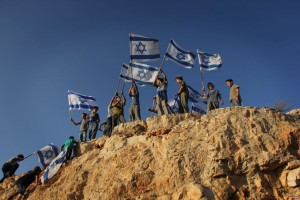 Children in the West Bank settlement of Itamar wave Israeli flags on a hilltop. (File Photo: VOA / Rebecca Collard)