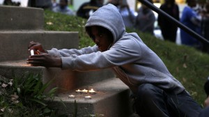 A boy lights candles during a vigil to remember Vonderrit D. Myers, Thursday, Oct. 9, 2014, in St. Louis. (Photo: Jeff Roberson / Associated Press)