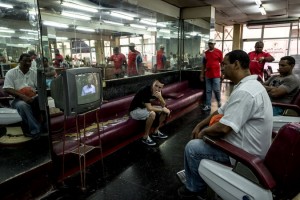 Watching President Raúl Castro's speech in a barbershop in Havana on Saturday. Mr. Castro declared victory for the Cuban revolution and thanked President Obama for opening a new chapter, while also asserting that restored relations with the United States would not mean the end of Communist rule in Cuba (Photo: Meridith Kohut for The New York Times)