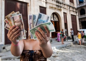A woman shows Cuban pesos CUP, left, and convertible pesos CUC, right, on October 22, 2013 in Havana. (Photo: Yamil Lage / AFP via Getty Images)