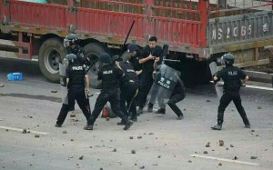 Riot police beating protestors in Linshui (Photo: telegraph.co.uk)